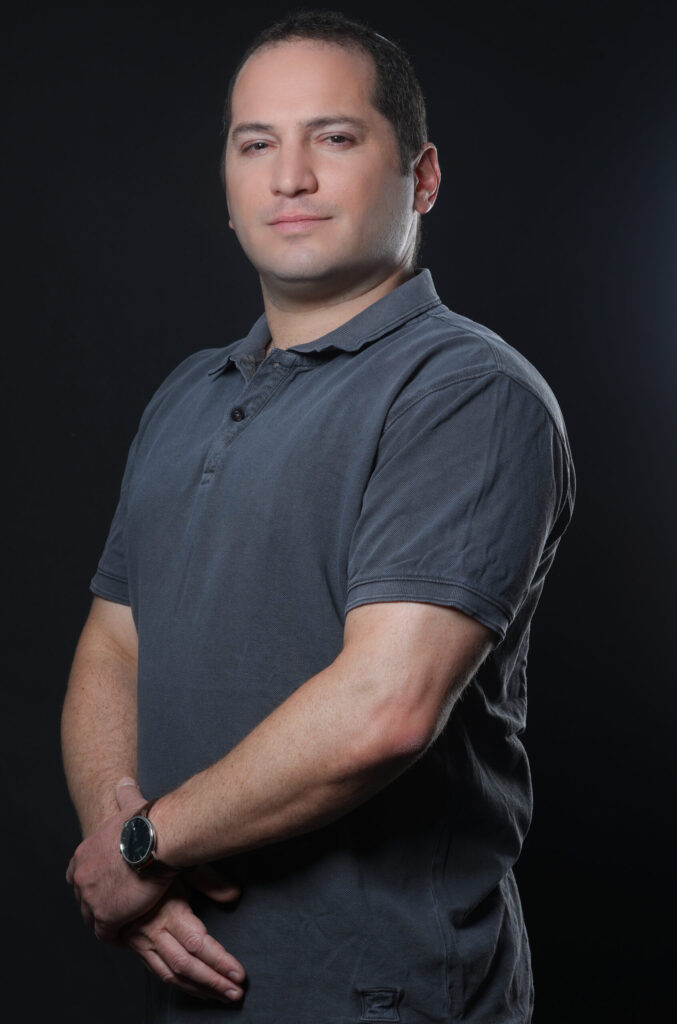 Headshot of a man wearing a gray polo shirt.